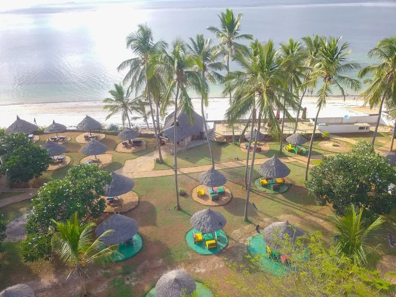 Pogled na tropski vrt in slamnate senčnike ob obali